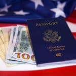 Passport, US dollar bills, and American flag background symbolizing immigration and financial success.