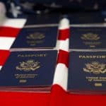 U.S. passports on an American flag-themed background, symbolizing travel and immigration.